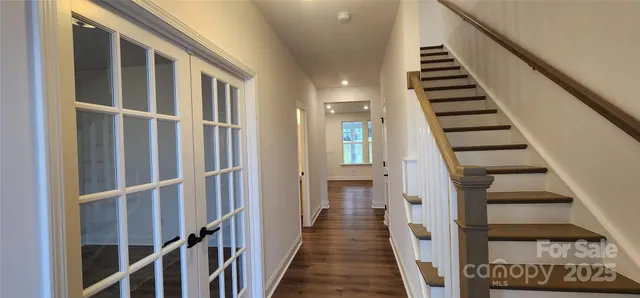 a view of staircase with wooden floor and white walls