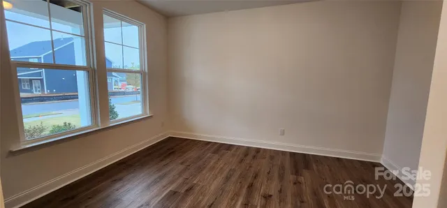 a view of a room that has wooden floor and windows