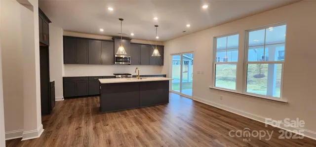 a large kitchen with kitchen island a large counter space a sink appliances and cabinets