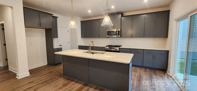 a kitchen with a sink a stove a refrigerator and a oven