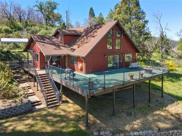 a front view of a house with balcony and trees