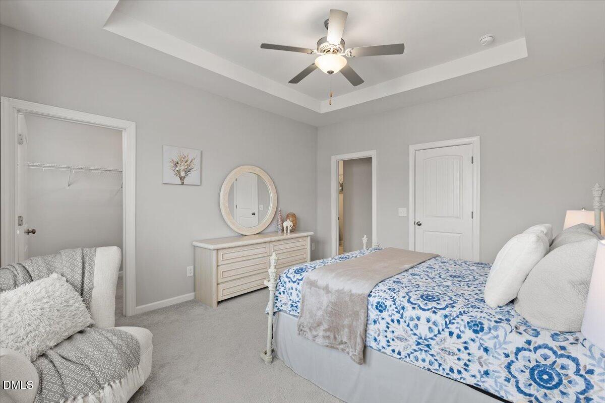 435 Leighann Ridge Lane Rolesville, NC 27571 - Photo 14 of 21 a bedroom with a bed and a chandelier