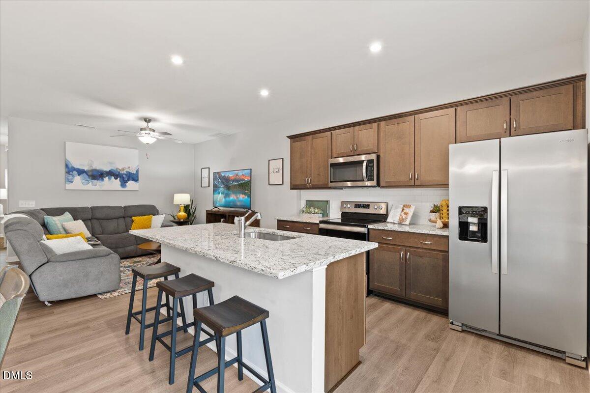 435 Leighann Ridge Lane Rolesville, NC 27571 - Photo 7 of 21 a kitchen with stainless steel appliances granite countertop a refrigerator a stove top oven a sink dishwasher and white cabinets with wooden floor