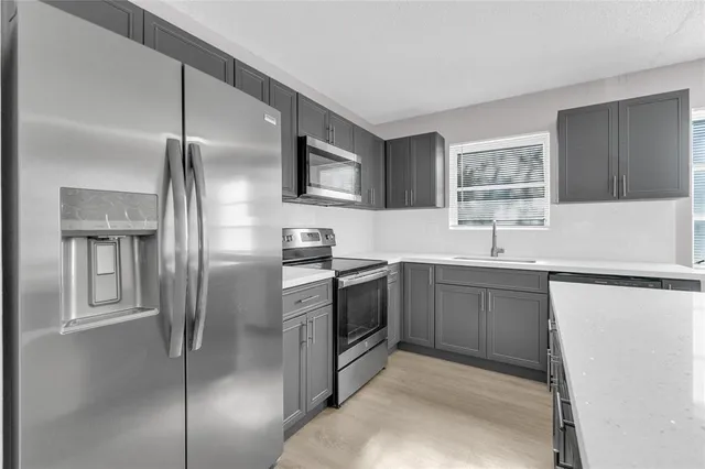 a kitchen with a refrigerator sink and cabinets