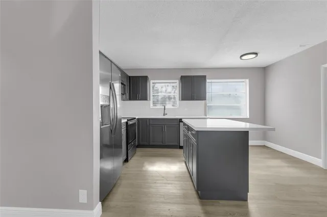a kitchen with stainless steel appliances a refrigerator and a sink
