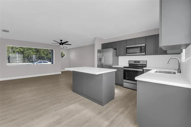 a kitchen with kitchen island a sink dishwasher stove and oven with wooden floor