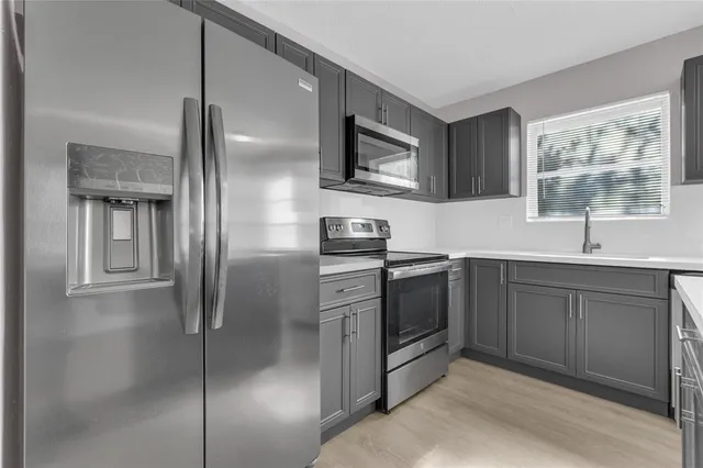 a kitchen with a refrigerator sink and cabinets