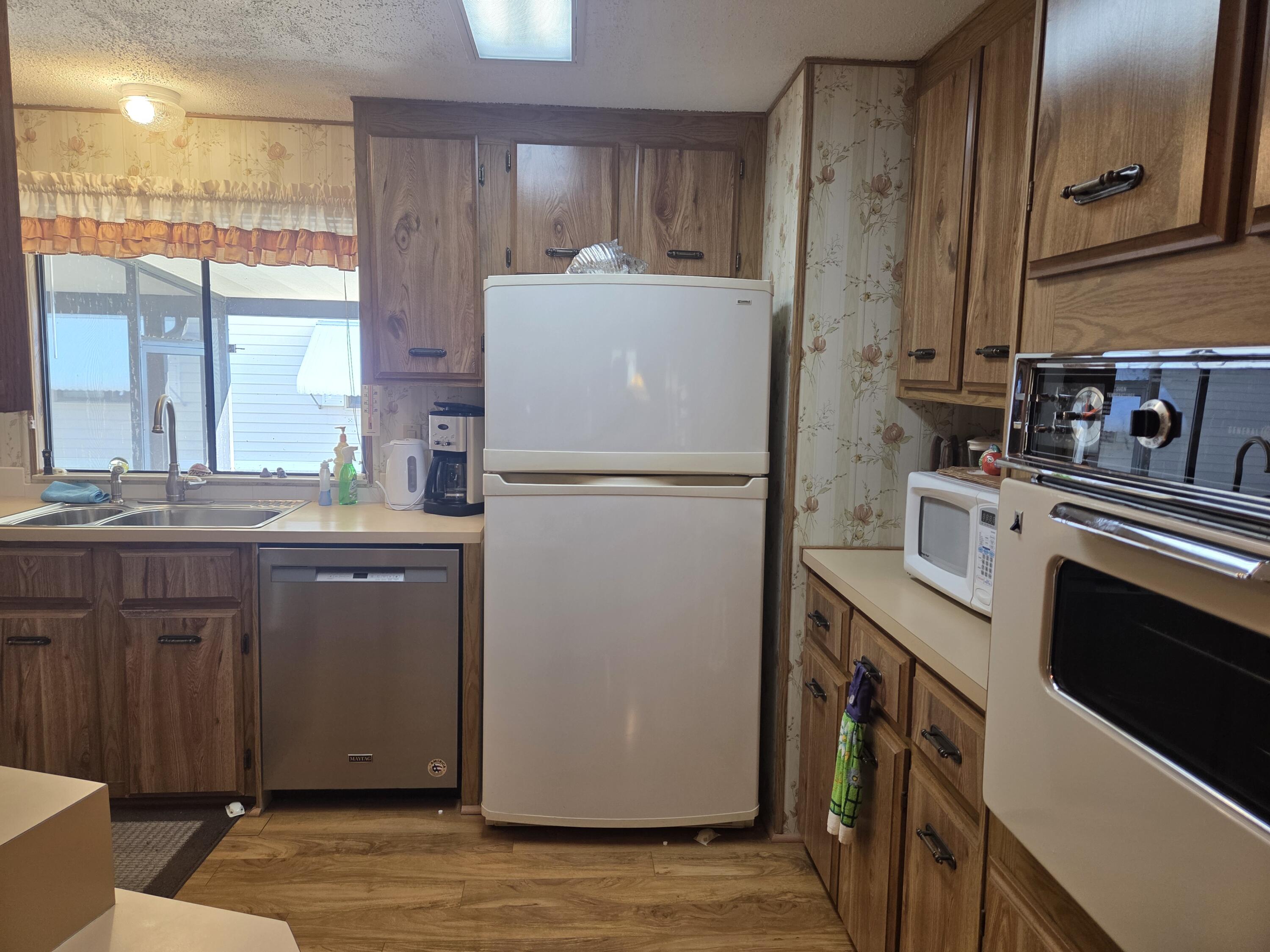 7375 Southeast Independence Avenue Hobe Sound, FL 33455 - Photo 9 of 25 a kitchen with a refrigerator and a sink