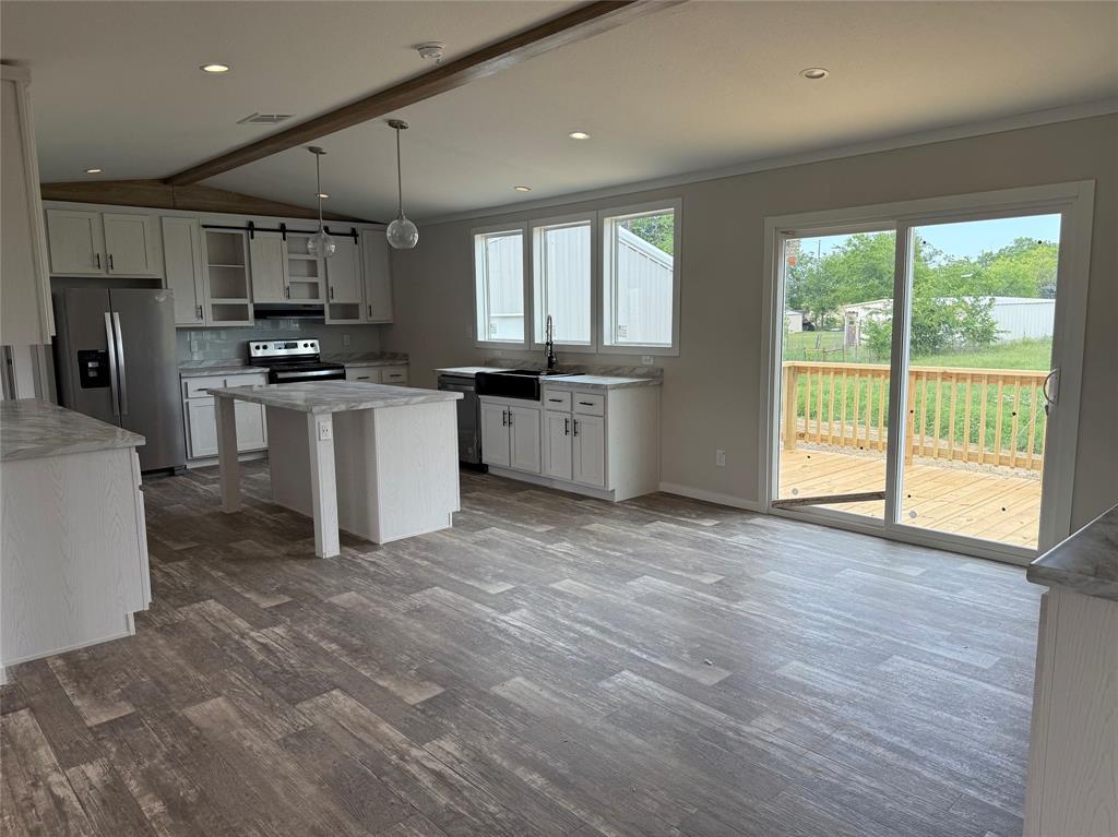 163 Red Fox Court Weatherford, TX 76088 - Photo 4 of 22 a large kitchen with stainless steel appliances granite countertop a stove a sink and a refrigerator