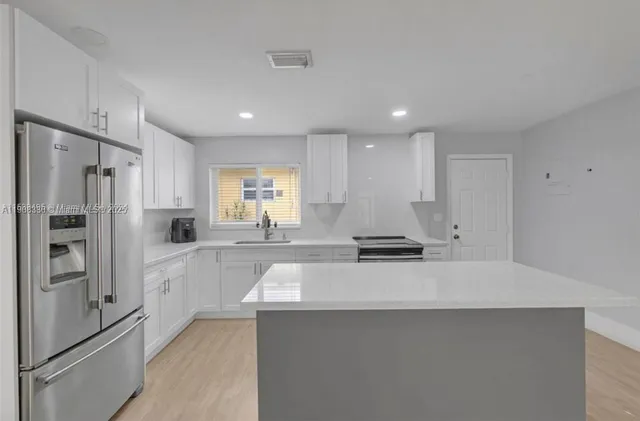 a kitchen with stainless steel appliances a refrigerator sink and stove