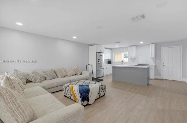 a living room with furniture and kitchen view