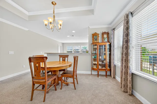 a view of a dining room with furniture and a chandelier