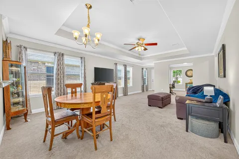 a living room with furniture a chandelier and a flat screen tv
