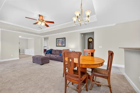 a dining room with furniture a chandelier and a rug