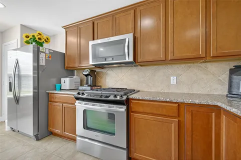 a kitchen with granite countertop stainless steel appliances a stove a microwave and cabinets