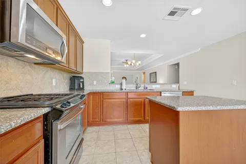 a kitchen with stainless steel appliances granite countertop a sink stove and cabinets