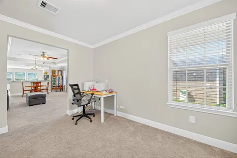 a view of a workspace with furniture and a window