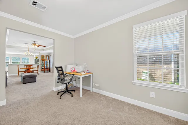 a view of a workspace with furniture and a window