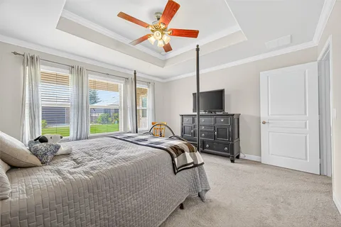 a bedroom with a bed and a flat tv screen on dresser
