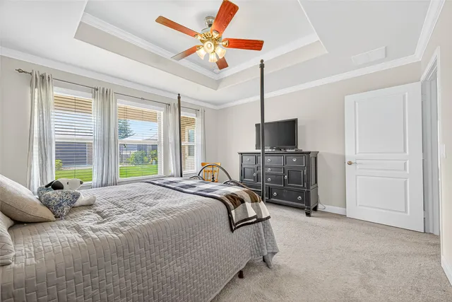 a bedroom with a bed and a flat tv screen on dresser