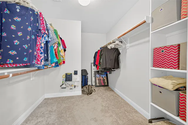 a view of walk in closet with clothes and shoes