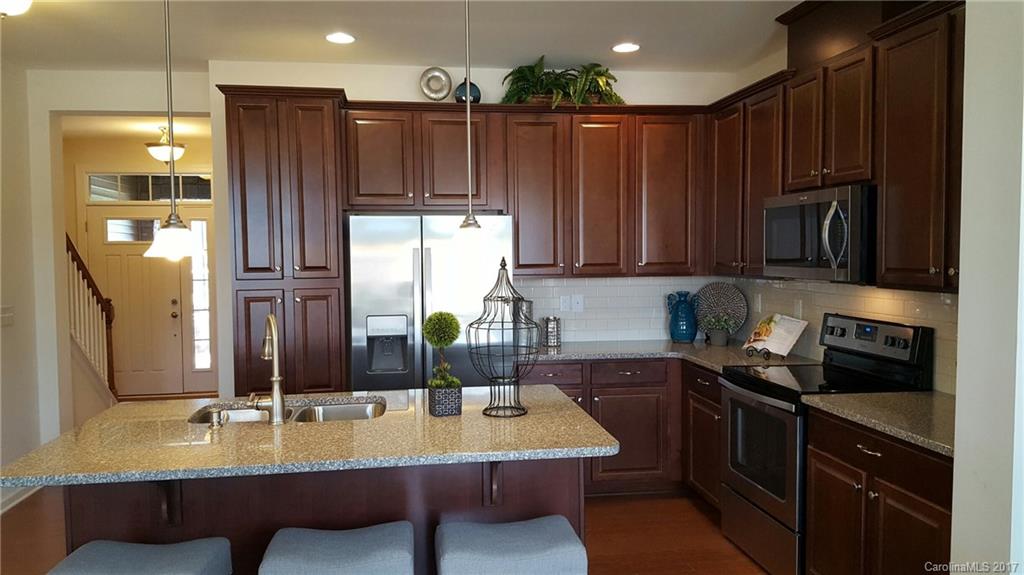 1128 Roderick Drive, Unit 70 FALKNER B Fort Mill, SC 29708 - Photo 17 of 20 a kitchen with wooden cabinets a sink and a stove