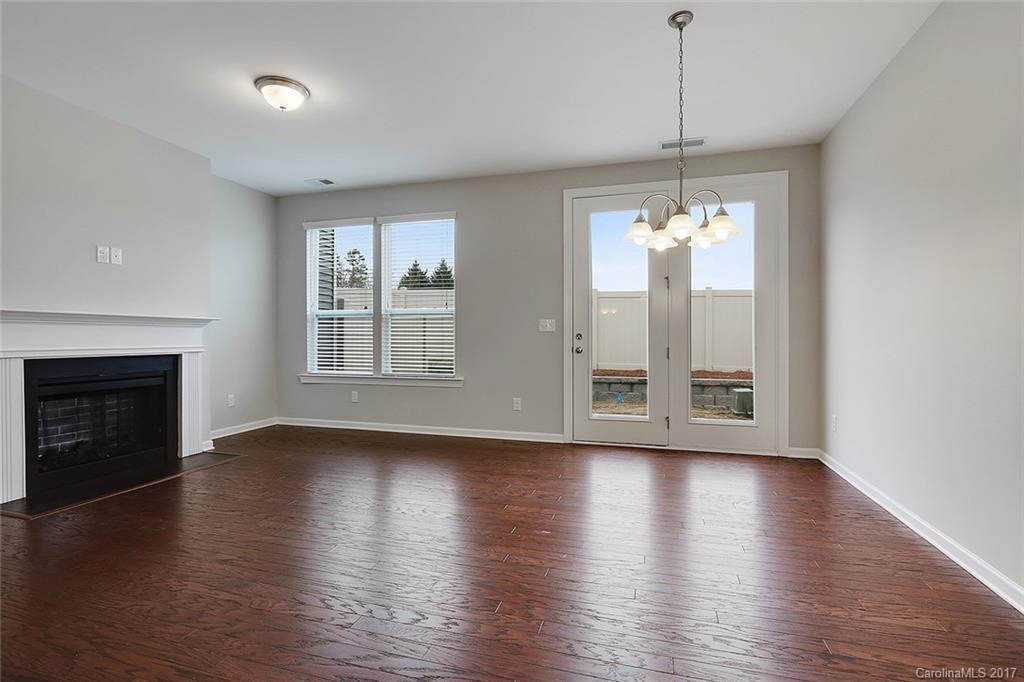 1128 Roderick Drive, Unit 70 FALKNER B Fort Mill, SC 29708 - Photo 8 of 20 a view of an empty room with wooden floor fireplace and a window