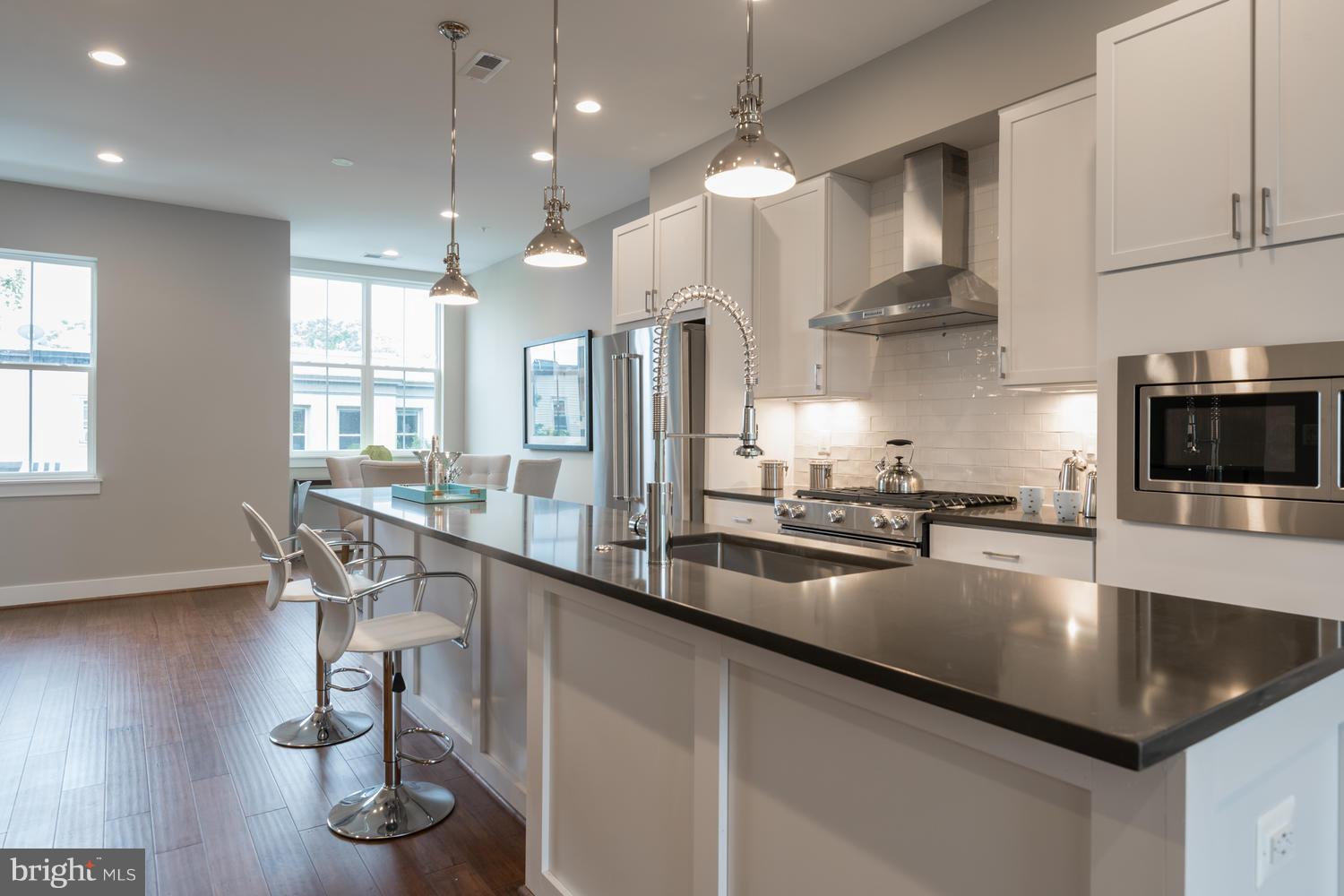 1007 Girard Street Northwest, Unit B Washington, DC 20001 - Photo 6 of 30 a kitchen with stainless steel appliances granite countertop a sink a stove and a wooden floors