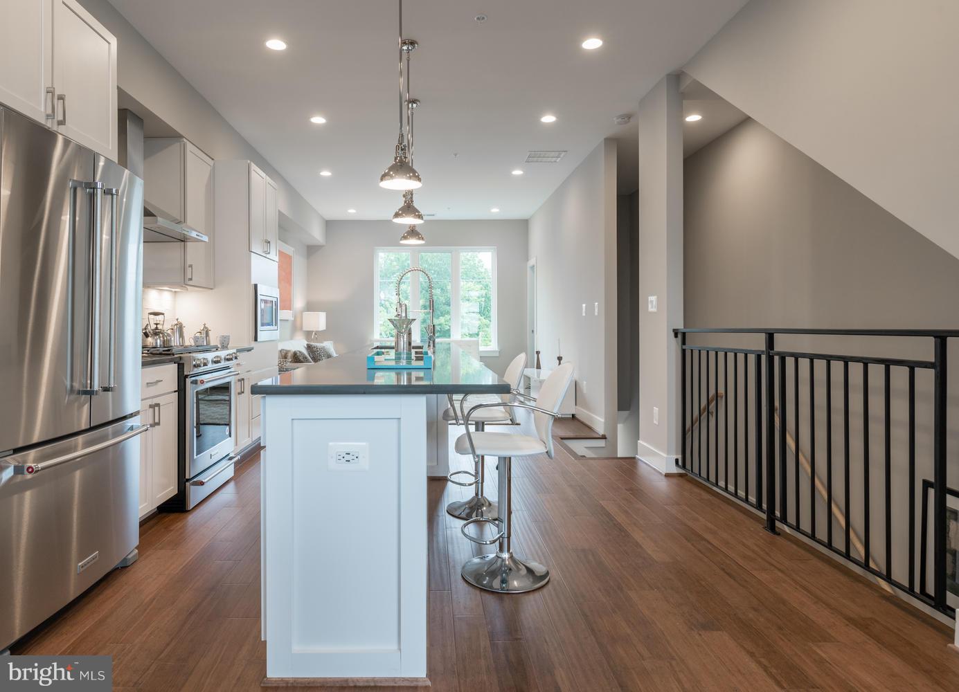 1007 Girard Street Northwest, Unit B Washington, DC 20001 - Photo 7 of 30 a kitchen with stainless steel appliances granite countertop a refrigerator a sink dishwasher a stove and white cabinets with wooden floor