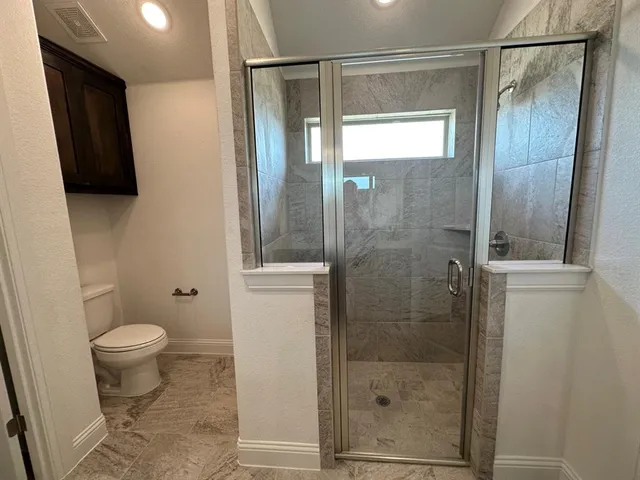 a bathroom with a shower and a toilet