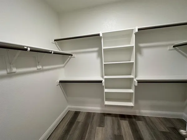 a view of walk in closet with empty racks