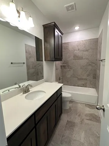 a bathroom with a bathtub sink vanity and mirror