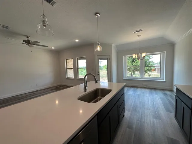 a kitchen with kitchen island a wooden floor and a large window