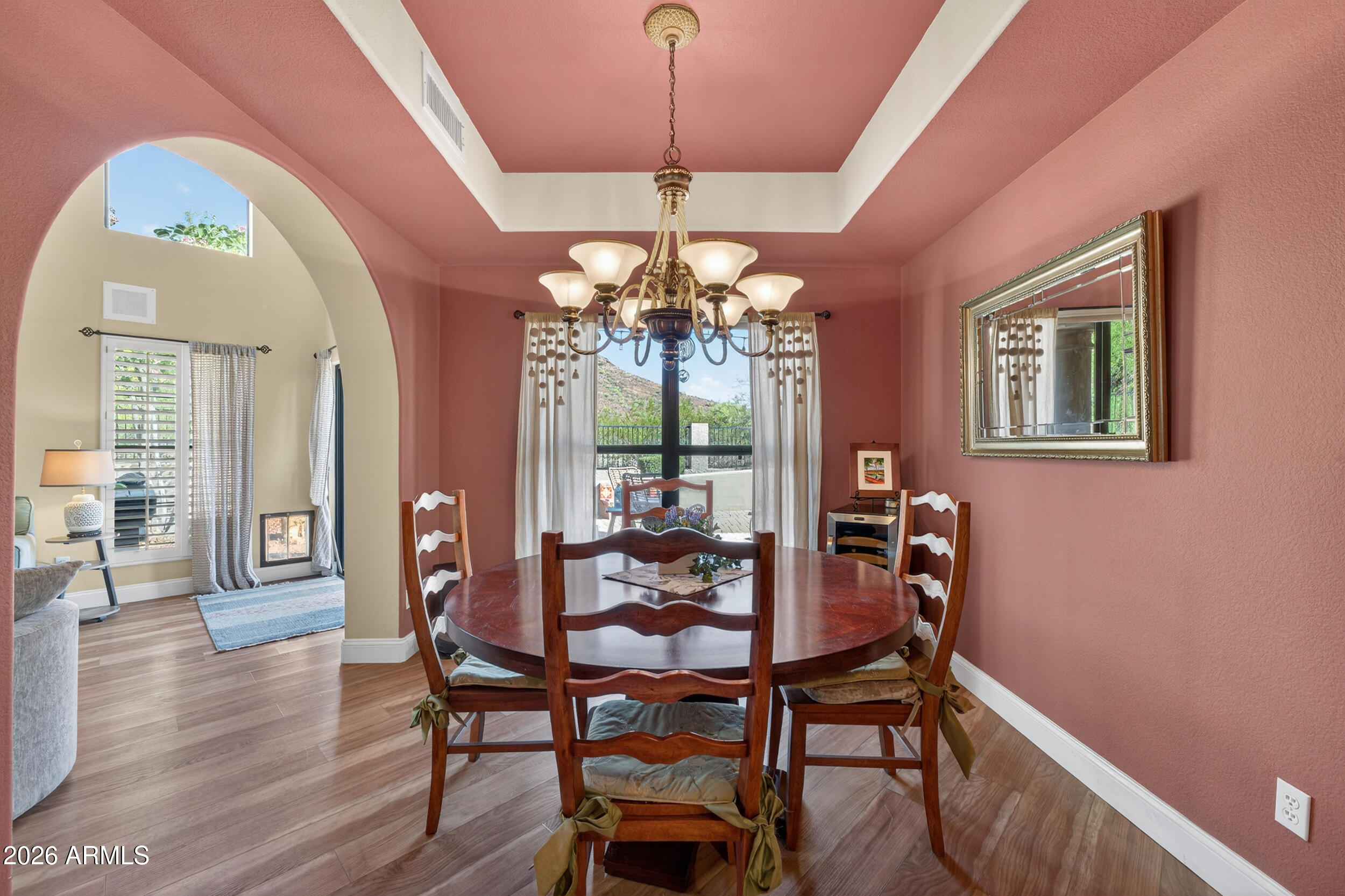 1539 East Winged Foot Road Phoenix, AZ 85022 - Photo 30 of 64 a dining room with wooden floor a chandelier a wooden table and chairs