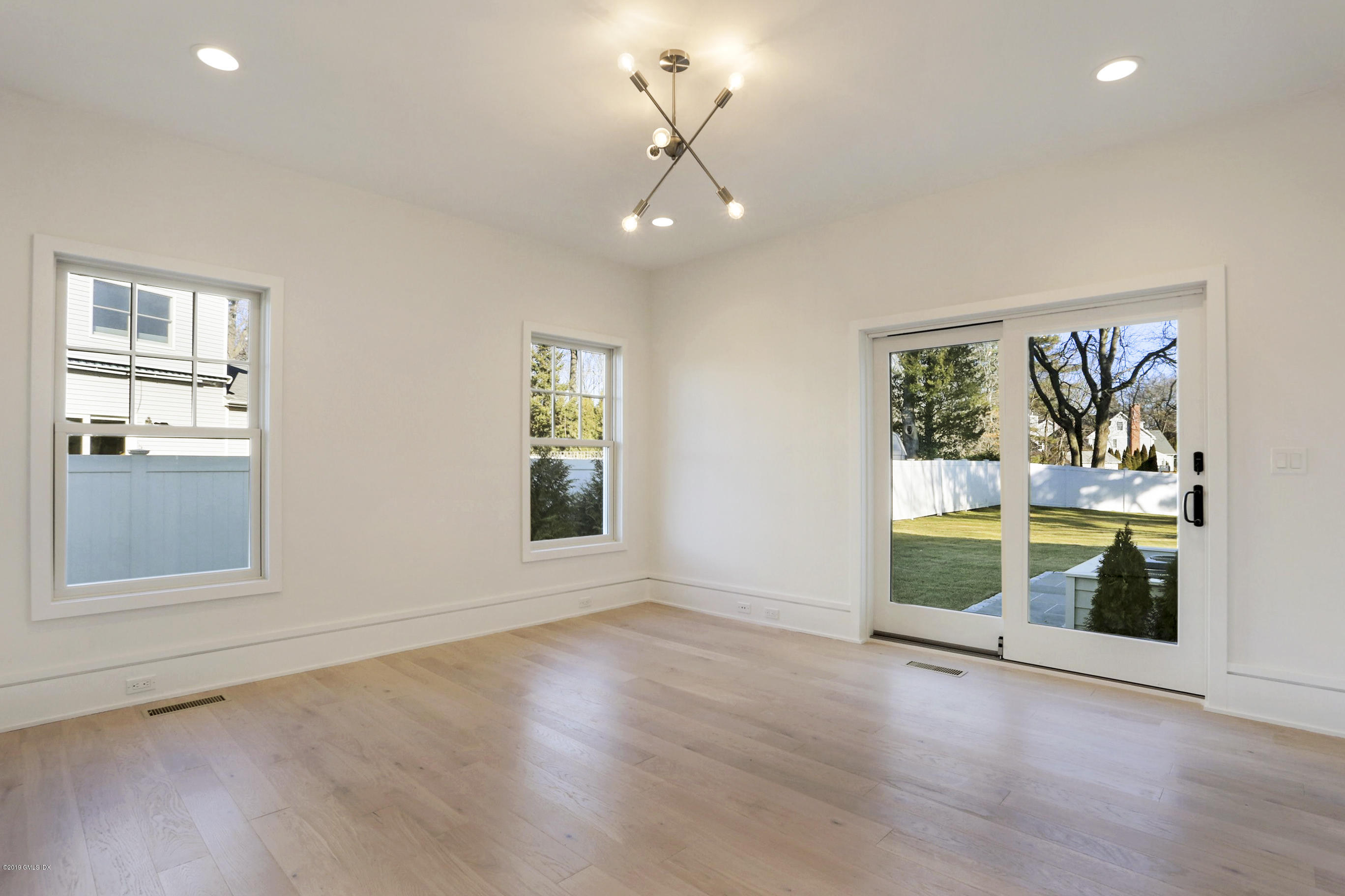 84 Circle Drive Greenwich, CT 06830 - Photo 14 of 25 an empty room with wooden floor and windows
