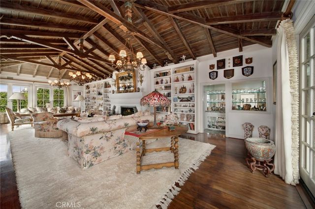 a spacious bedroom with a bed a couch and a chandelier