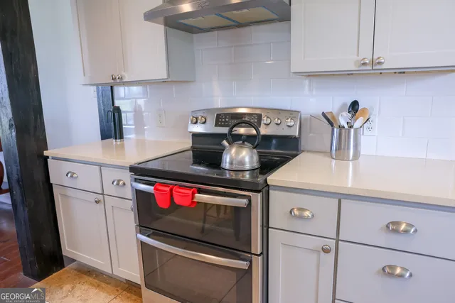 a kitchen with stainless steel appliances granite countertop a sink stove and cabinets