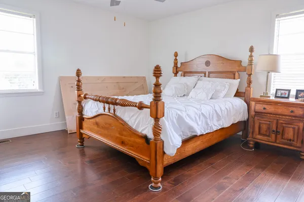 a bedroom with a bed and wooden floor