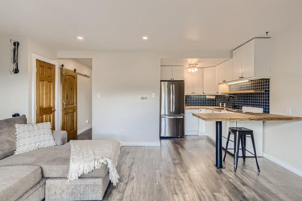 180 Evergreen Road, Unit 204 Dillon, CO 80435 - Photo 3 of 13 a kitchen with stainless steel appliances a refrigerator and wooden floor