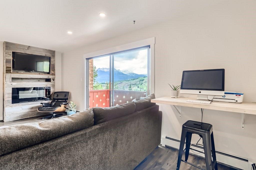180 Evergreen Road, Unit 204 Dillon, CO 80435 - Photo 4 of 13 a living room with furniture a flat screen tv and a floor to ceiling window
