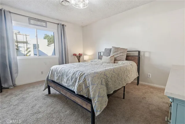 a bed sitting in a bedroom next to a window