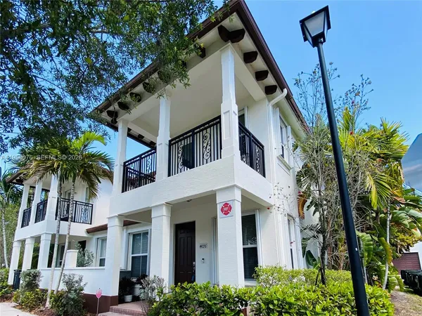 a front view of a house with a tree