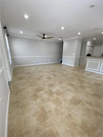 an empty room with kitchen and window