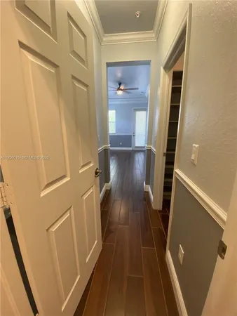 a view of a hallway with wooden floor and staircase