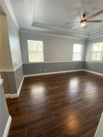 en empty room with window and wooden floor