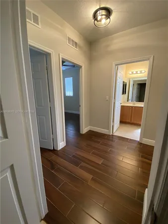 a view of a hallway with wooden floor and livingroom view