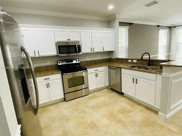 a kitchen with appliances a sink and cabinets