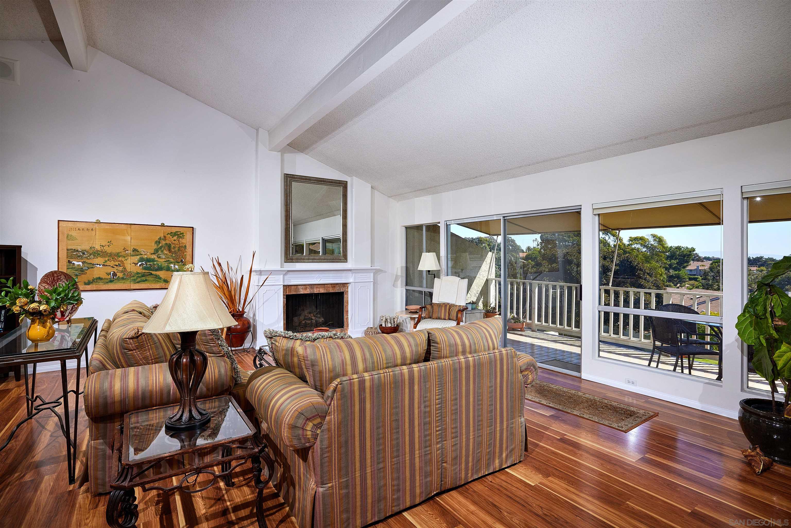 2035 Caminito Circulo Sur La Jolla, CA 92037 - Photo 3 of 22 a living room with furniture a fireplace and a floor to ceiling window