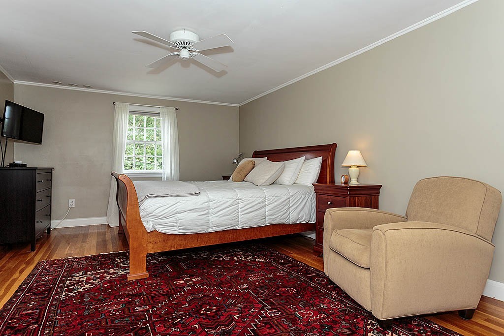 60 Watson Road Belmont, MA 02478 - Photo 10 of 21 a bedroom with a bed a couch and a flat screen tv