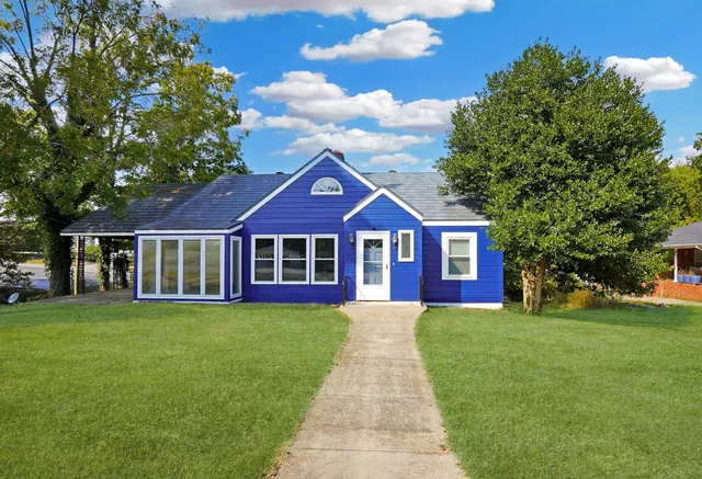 a view of a house with a yard and sitting area